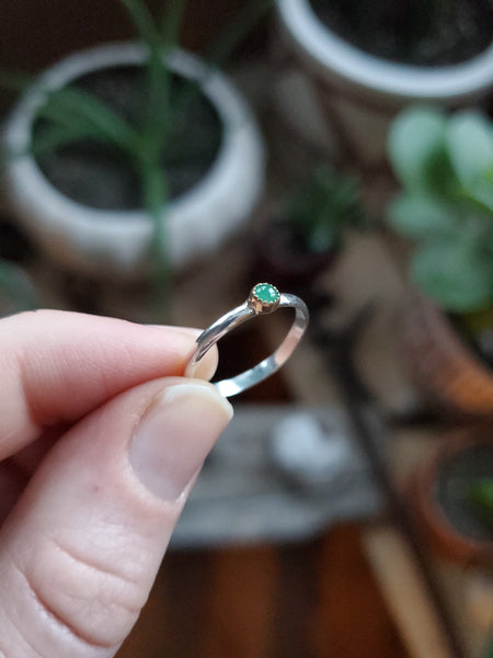 3mm Emerald set in 14k gold on a sterling silver size 5.25 ring band