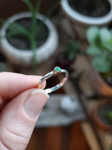 3mm Emerald set in 14k gold on a sterling silver size 5.25 ring band