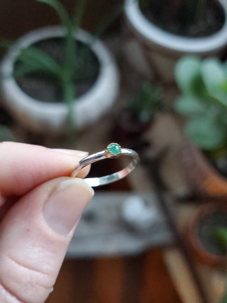 3mm Emerald set in 14k gold on a sterling silver size 5.25 ring band