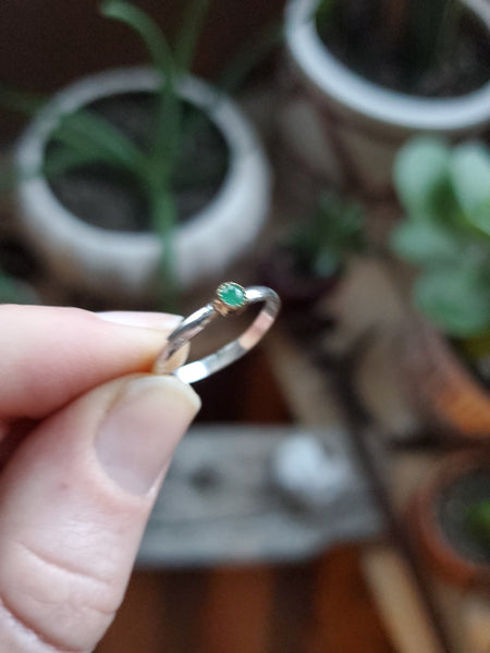 3mm Emerald set in 14k gold on a sterling silver size 5.25 ring band