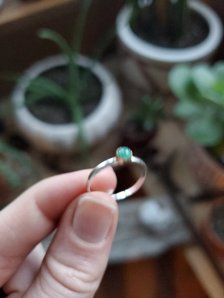 4mm Emerald set in 14k Gold on a Size 5.5 Silver band