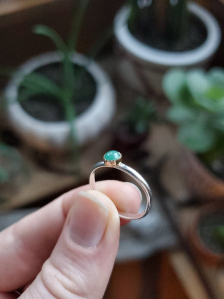 4mm Emerald set in 14k Gold on a Size 5.5 Silver band