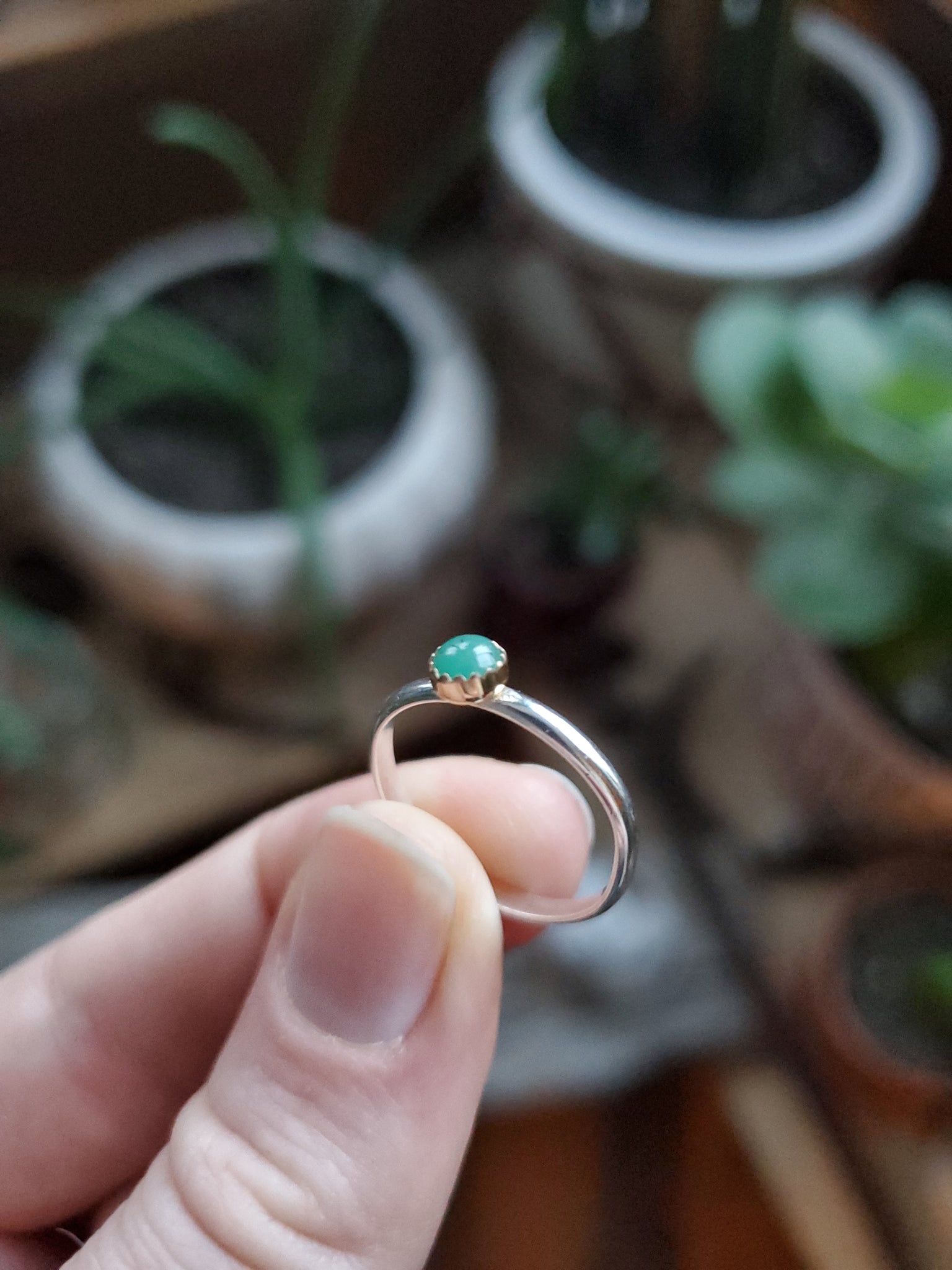 4mm Emerald set in 14k Gold on a Size 5.5 Silver band